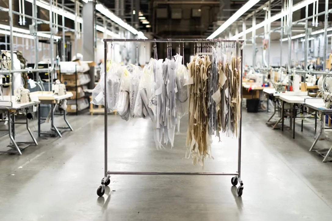 OEM waterproof outerwear workshop with pattern pieces and sewing stations for B2B jacket manufacturing buyers